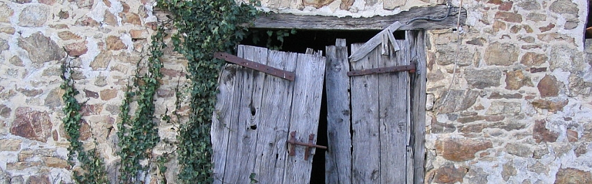 Een authentieke poort ten prooi gevallen aan de tand des tijds in een van de oude schuren op Domaine du Masvieux